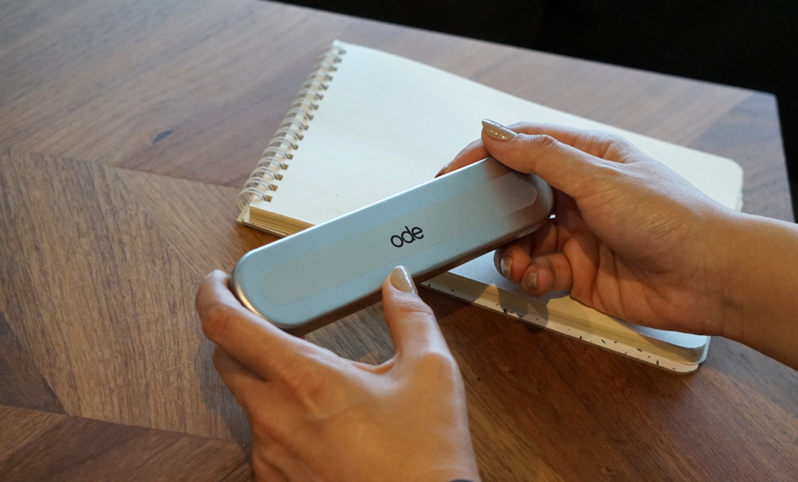 The closed Ode tin held in two hands, the ode mark on its lid